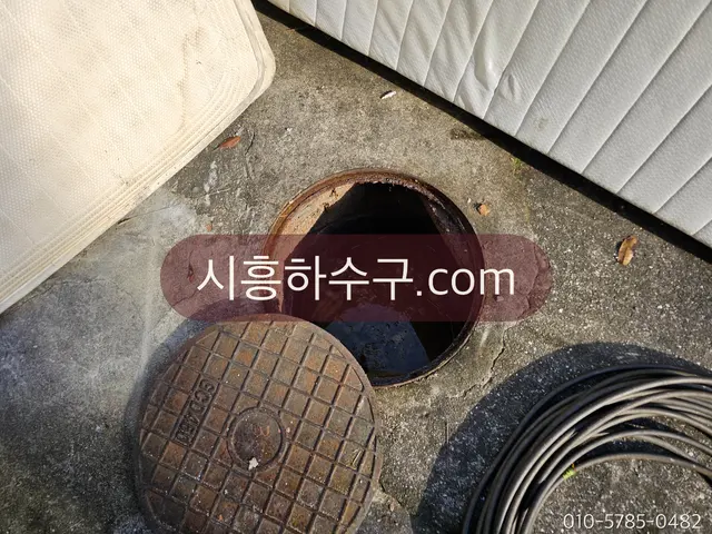 뚜껑을 연 오수받이에서 막힌 구간을 확인하는 모습