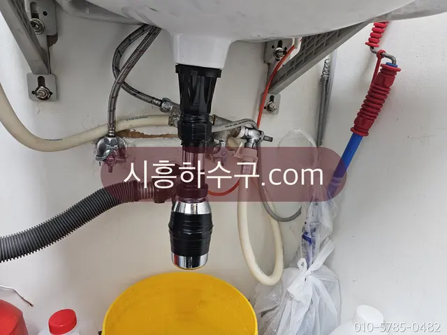 싱크대 아래 배수 배관을 정리해 연결한 상태