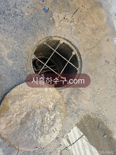 겨울 옥외 맨홀과 얼어붙은 주변 배관