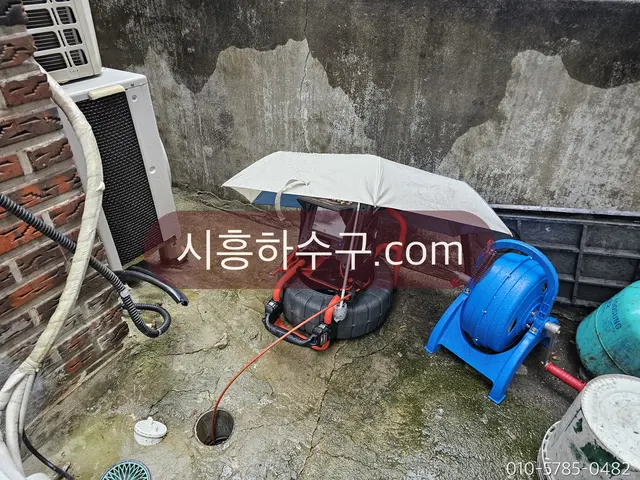 옥외에서 내시경 릴을 풀어 배관을 조사하는 모습