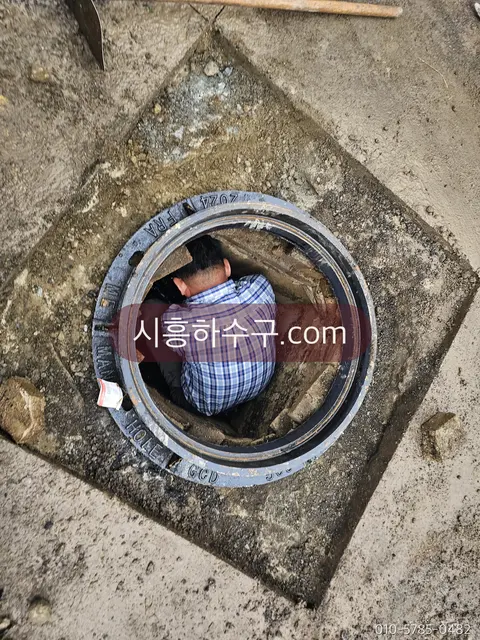 맨홀 안으로 들어가 본관 상태를 확인하는 작업