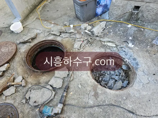 도로 맨홀을 열고 역류 구간을 처리하는 현장