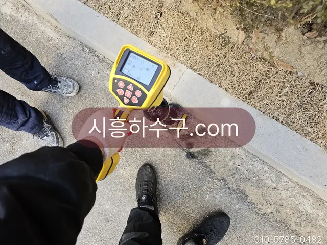 청음 탐지기로 바닥 아래 급수관의 누수 지점을 찾는 작업