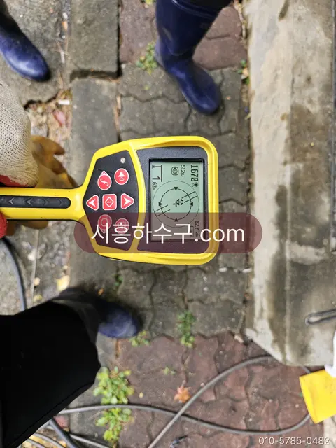 청음 탐지기로 지하 급수관 누수 지점을 찾는 작업