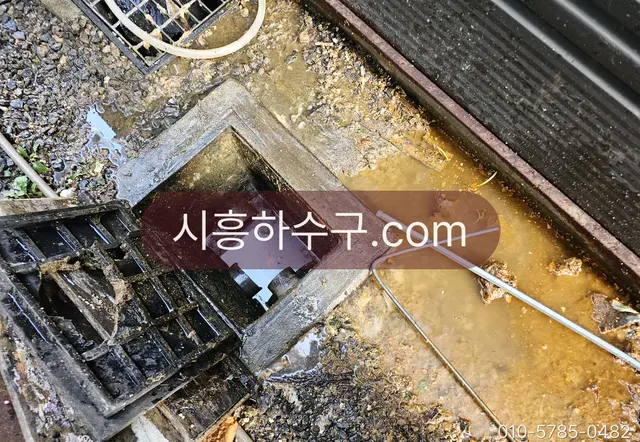 오수받이 안에 가라앉은 슬러지와 토사를 걷어내는 준설 작업