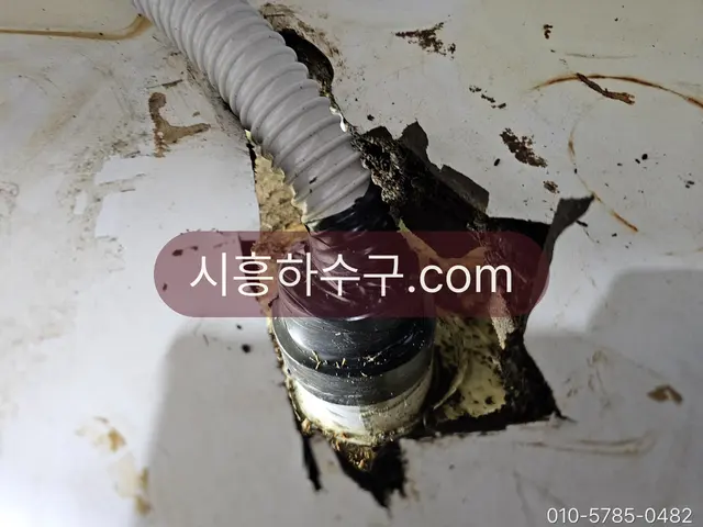 바닥 배수구로 이어진 에어컨 드레인 호스 연결부